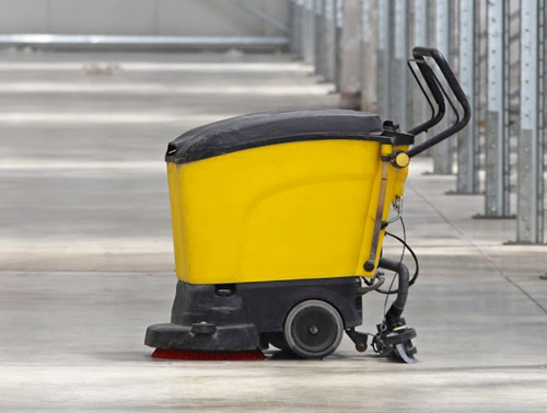 Laveuse de sols commerciaux jaune nettoyant un établissement
